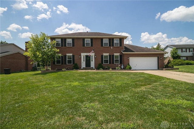 6377 Holloway Dr, Liberty Twp, OH 45044 - colonial home featuring an attached garage, driveway, a front yard, and brick siding