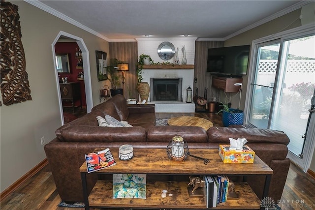 6377 Holloway Dr, Liberty Twp, OH 45044 - living area with wood finished floors, crown molding, a brick fireplace, and arched walkways