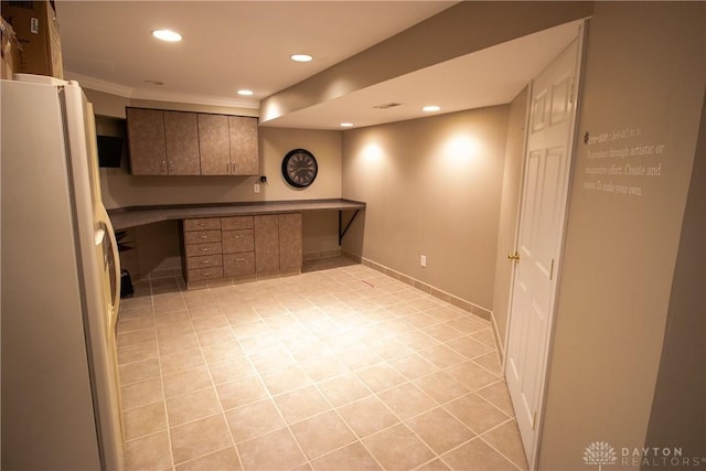 6377 Holloway Dr, Liberty Twp, OH 45044 - kitchen featuring freestanding refrigerator, recessed lighting, light tile patterned flooring, crown molding, and brown cabinets