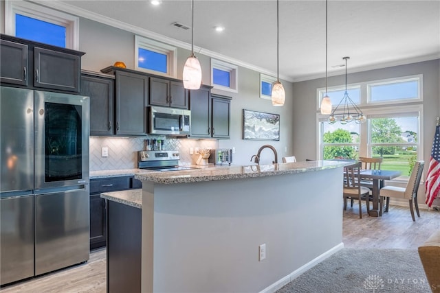 4374 Fairway Ln, Lebanon, OH 45036 - kitchen featuring appliances with stainless steel finishes, ornamental molding, decorative backsplash, a kitchen island with sink, and hanging light fixtures