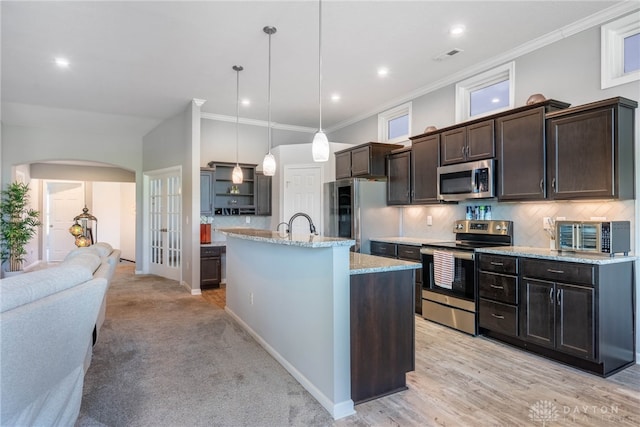 4374 Fairway Ln, Lebanon, OH 45036 - kitchen featuring appliances with stainless steel finishes, arched walkways, dark brown cabinetry, decorative light fixtures, and tasteful backsplash