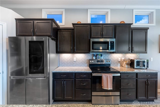 4374 Fairway Ln, Lebanon, OH 45036 - kitchen featuring stainless steel appliances, light stone countertops, decorative backsplash, dark brown cabinetry, and crown molding