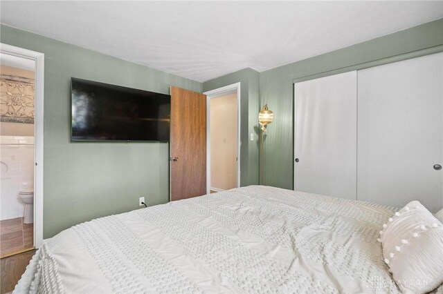 1009 Cottage Court Dr, Fairborn, OH 45324 - bedroom with a closet, wood finished floors, and ensuite bathroom