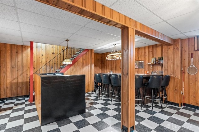 1009 Cottage Court Dr, Fairborn, OH 45324 - indoor dry bar with tile patterned floors, wooden walls, a paneled ceiling, and stairs