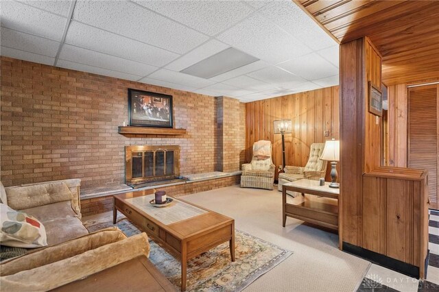 1009 Cottage Court Dr, Fairborn, OH 45324 - carpeted living area featuring a drop ceiling, a brick fireplace, and wooden walls