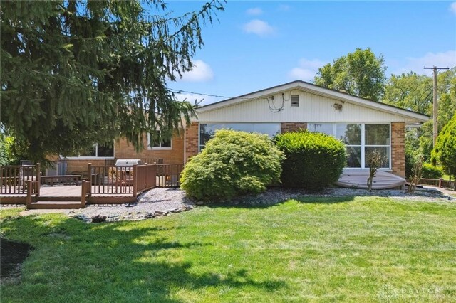 1009 Cottage Court Dr, Fairborn, OH 45324 - back of house with a wooden deck, brick siding, and a yard