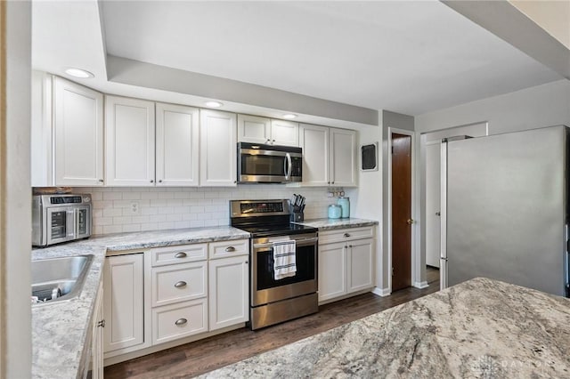 1009 Cottage Court Dr, Fairborn, OH 45324 - kitchen featuring stainless steel appliances, dark wood-style flooring, light stone counters, tasteful backsplash, and recessed lighting