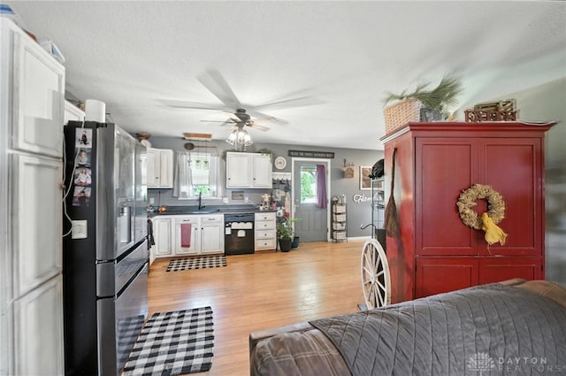 204 Ivy Creek Cv, Jamestown Vlg, OH 45335 - kitchen with stainless steel fridge, black dishwasher, open floor plan, ceiling fan, and light wood-style flooring