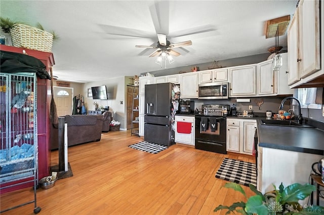 204 Ivy Creek Cv, Jamestown Vlg, OH 45335 - kitchen with black appliances, dark countertops, ceiling fan, open floor plan, and light wood-style flooring