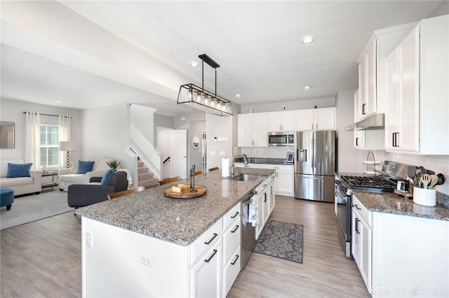 2246 Cold Stream Dr, Centerville, OH 45458 - kitchen with stainless steel appliances, tasteful backsplash, open floor plan, light wood-style floors, and under cabinet range hood