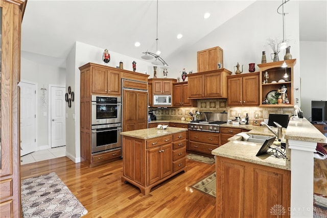 6885 Willow Creek Run, Liberty Twp, OH 45044 - kitchen featuring stainless steel appliances, brown cabinetry, open shelves, hanging light fixtures, and lofted ceiling
