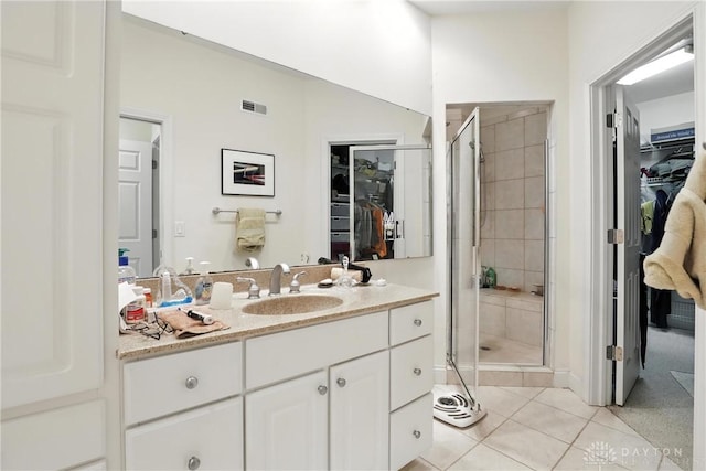 6885 Willow Creek Run, Liberty Twp, OH 45044 - full bathroom featuring a walk in closet, vanity, a shower stall, and tile patterned floors