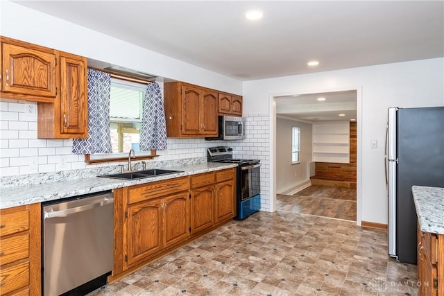2841 Prospect Dr, Fairborn, OH 45324 - kitchen with appliances with stainless steel finishes, tasteful backsplash, brown cabinetry, healthy amount of natural light, and recessed lighting