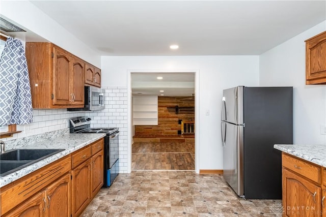 2841 Prospect Dr, Fairborn, OH 45324 - kitchen with stainless steel appliances, brown cabinetry, tasteful backsplash, light stone countertops, and recessed lighting