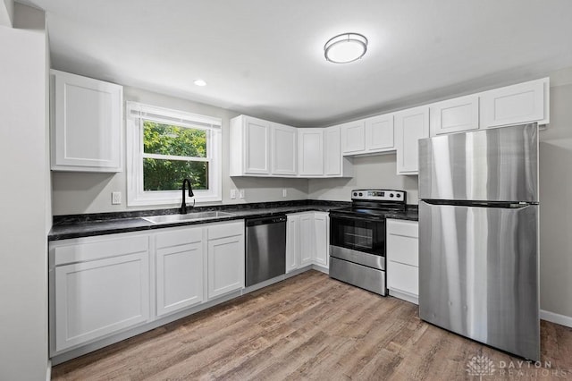 9351 Marcella Dr, Franklin, OH 45005 - kitchen featuring stainless steel appliances, white cabinetry, light wood-style flooring, and dark countertops