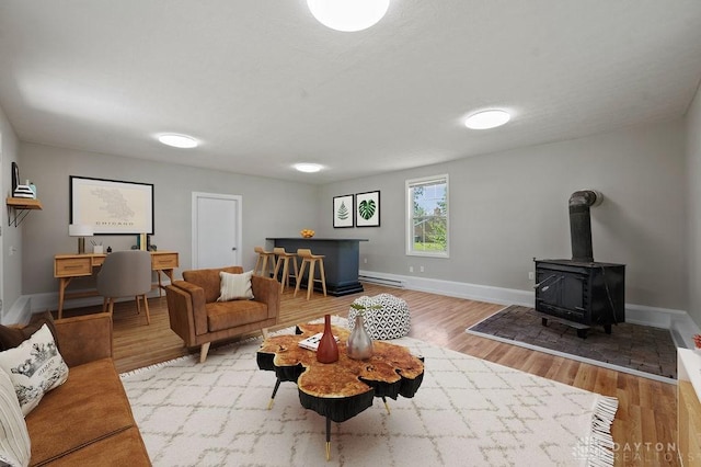 9351 Marcella Dr, Franklin, OH 45005 - living room featuring a baseboard heating unit, wood finished floors, and a wood stove