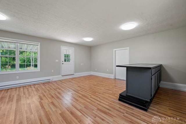 9351 Marcella Dr, Franklin, OH 45005 - unfurnished living room with light wood-style floors, a textured ceiling, and baseboard heating
