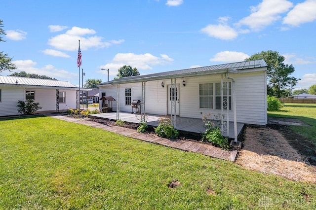 9351 Marcella Dr, Franklin, OH 45005 - view of front of house with a wooden deck, a front lawn, and a metal roof