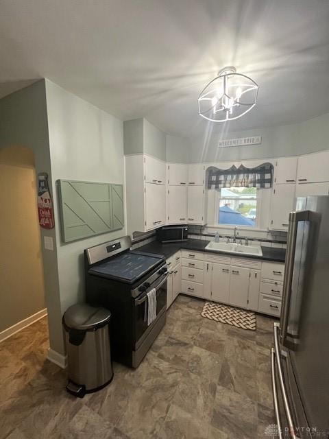 63 N Main St, West Alexandria, OH 45381 - kitchen with stainless steel appliances, white cabinets, and dark countertops