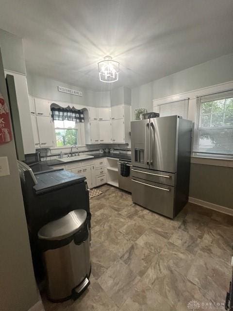 63 N Main St, West Alexandria, OH 45381 - kitchen featuring appliances with stainless steel finishes, dark countertops, healthy amount of natural light, and white cabinets
