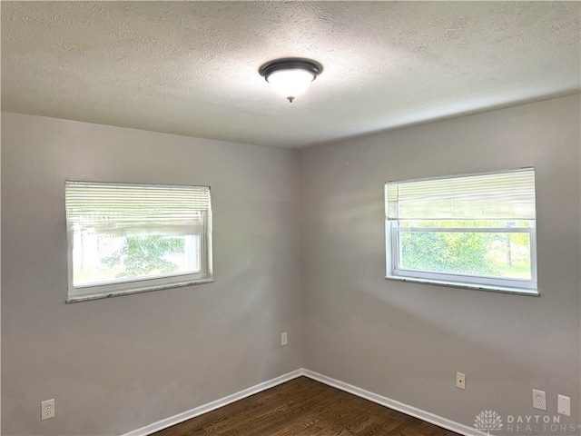 6686 Catskill Dr, Franklin, OH 45005 - empty room featuring dark wood-style floors, plenty of natural light, and a textured ceiling