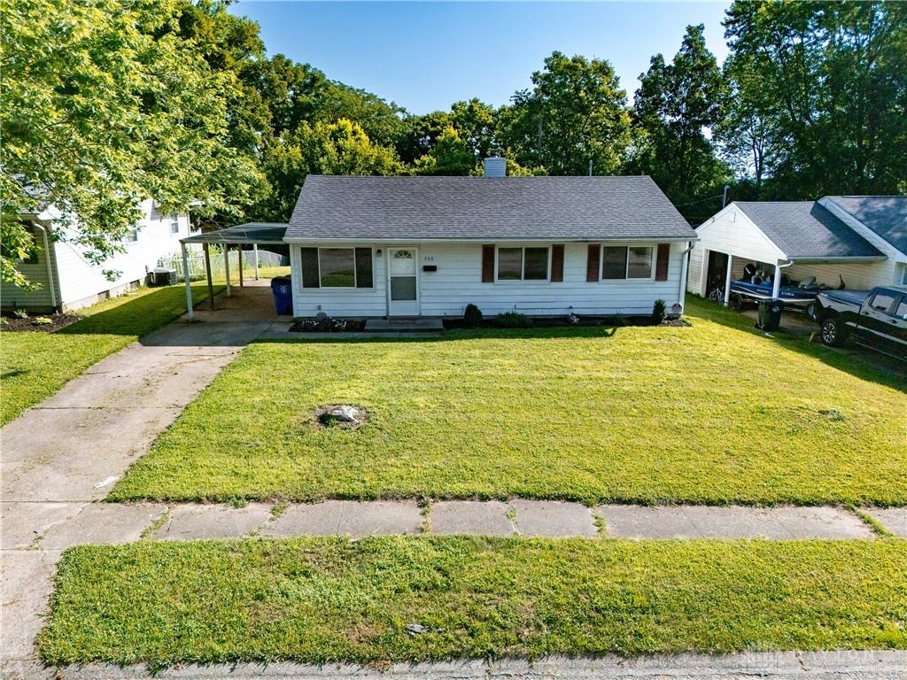 260 Chamberlin Dr, Hamilton, OH 45013 - view of front of property with driveway, a front yard, an attached carport, and a chimney