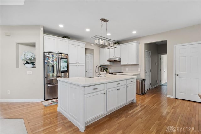 5535 Longhunter Chase Dr, Liberty Twp, OH 45044 - kitchen with stainless steel fridge, under cabinet range hood, light wood-style flooring, white cabinetry, and recessed lighting