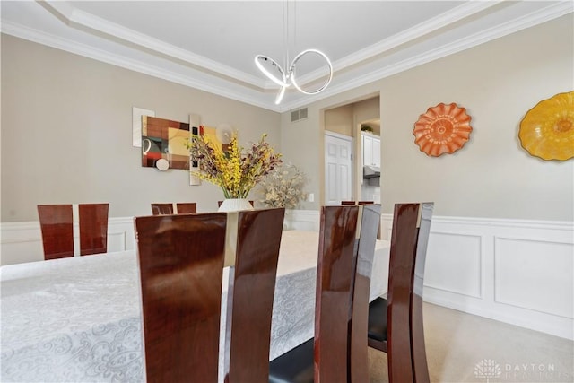 5535 Longhunter Chase Dr, Liberty Twp, OH 45044 - dining space featuring crown molding, a decorative wall, wainscoting, carpet flooring, and a chandelier