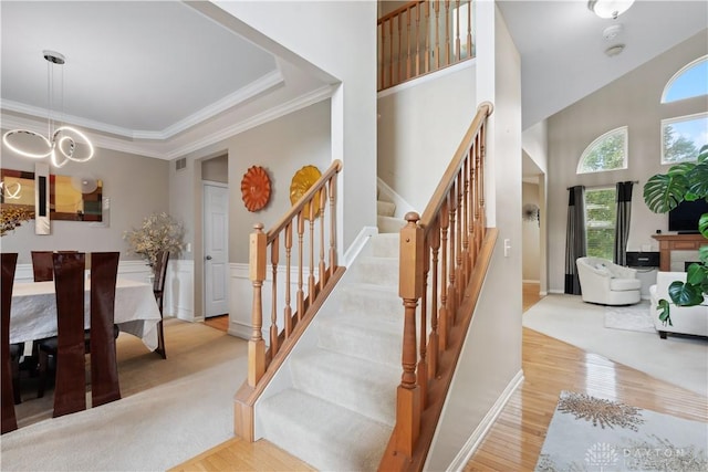 5535 Longhunter Chase Dr, Liberty Twp, OH 45044 - staircase with wood finished floors, a chandelier, crown molding, and a towering ceiling