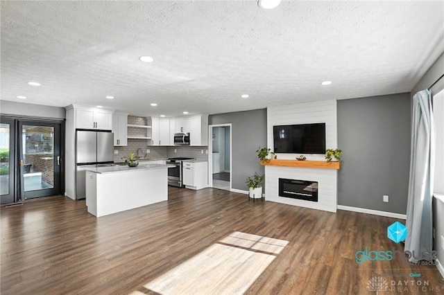 1937 Wilene Dr, Beavercreek, OH 45432 - kitchen with stainless steel appliances, a textured ceiling, open floor plan, a center island, and white cabinetry