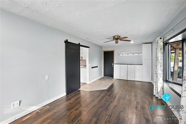 1937 Wilene Dr, Beavercreek, OH 45432 - spare room with a barn door, wood finished floors, ceiling fan, and a textured ceiling