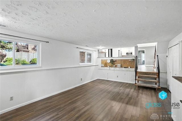1937 Wilene Dr, Beavercreek, OH 45432 - unfurnished living room featuring wood finished floors, a textured ceiling, and stairway