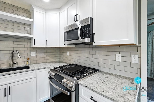 1937 Wilene Dr, Beavercreek, OH 45432 - kitchen featuring appliances with stainless steel finishes, open shelves, white cabinets, and decorative backsplash