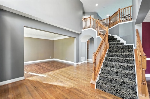 4300 Turtledove Way, Miamisburg, OH 45342 - stairs with arched walkways, wood finished floors, recessed lighting, and a towering ceiling