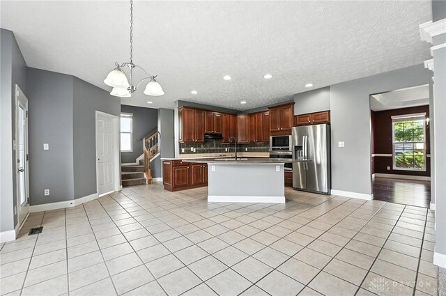4300 Turtledove Way, Miamisburg, OH 45342 - kitchen featuring stainless steel fridge with ice dispenser, built in microwave, light tile patterned floors, a chandelier, and backsplash