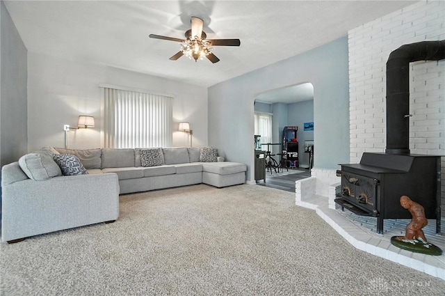 1551 W Main St, New Lebanon, OH 45345 - living area with carpet, a wood stove, arched walkways, and a ceiling fan
