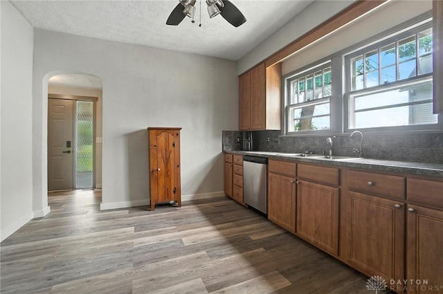 1551 W Main St, New Lebanon, OH 45345 - kitchen with stainless steel dishwasher, arched walkways, light wood-style flooring, ceiling fan, and a textured ceiling
