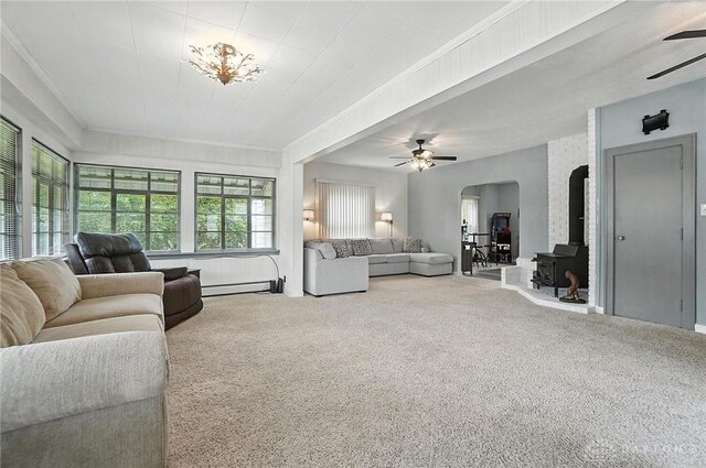 1551 W Main St, New Lebanon, OH 45345 - living area with ceiling fan, a baseboard radiator, a wood stove, and carpet floors