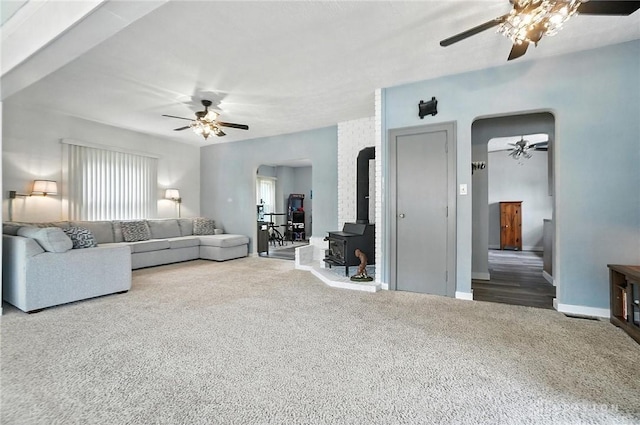 1551 W Main St, New Lebanon, OH 45345 - living room with a ceiling fan, arched walkways, carpet flooring, and a wood stove