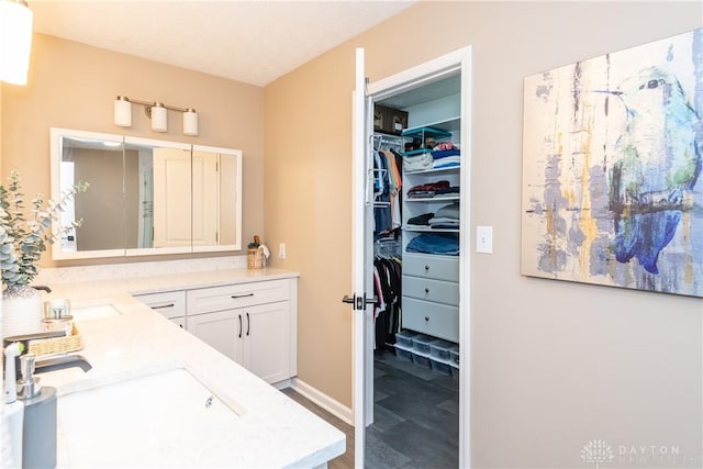100 Timberwind Ln, Vandalia, OH 45377 - bathroom with double vanity, wood finished floors, and a spacious closet
