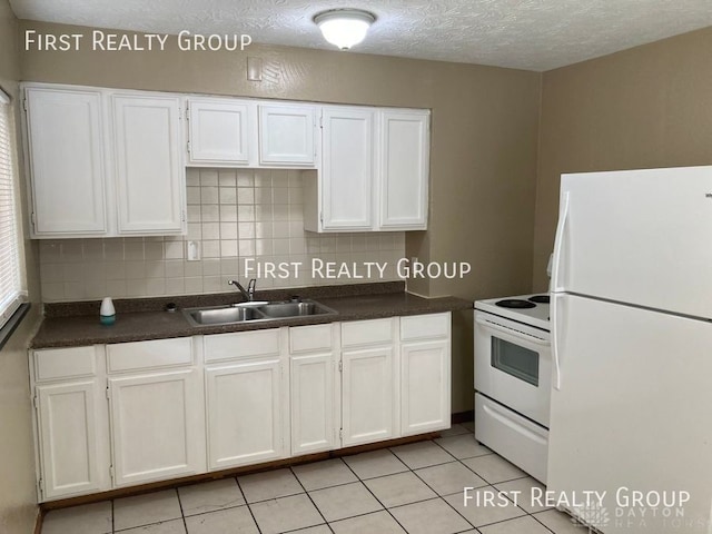 2011 Riverside Dr, Dayton, OH 45405 - kitchen with white appliances, backsplash, dark countertops, white cabinetry, and a textured ceiling