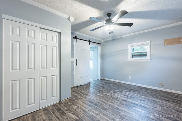 359 Gladys Ave, Franklin, OH 45005 - unfurnished bedroom with a barn door, crown molding, a textured ceiling, dark wood finished floors, and multiple windows