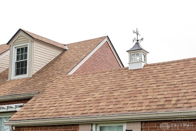 557 W N Bend Rd, Springfield Twp, OH 45224 - exterior view of roof with shingles, a downspout, brick siding, and gutters