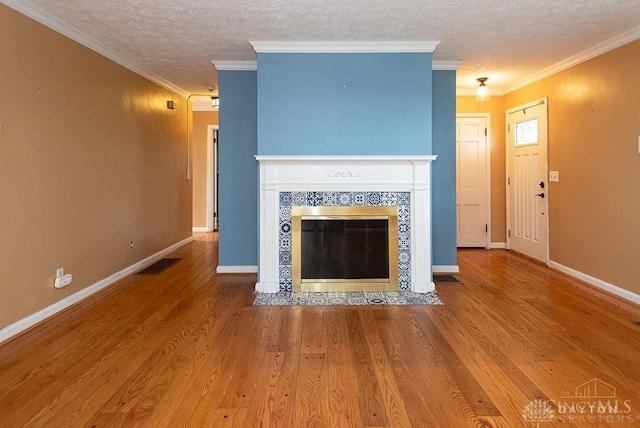 557 W N Bend Rd, Springfield Twp, OH 45224 - unfurnished living room with a textured ceiling, a fireplace, wood finished floors, and ornamental molding