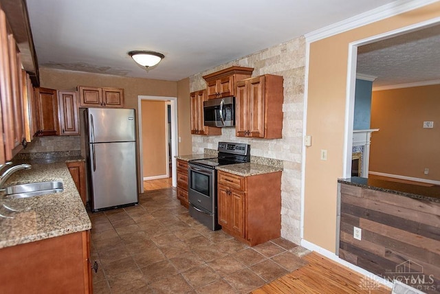 557 W N Bend Rd, Springfield Twp, OH 45224 - kitchen with appliances with stainless steel finishes, brown cabinetry, backsplash, light stone counters, and crown molding