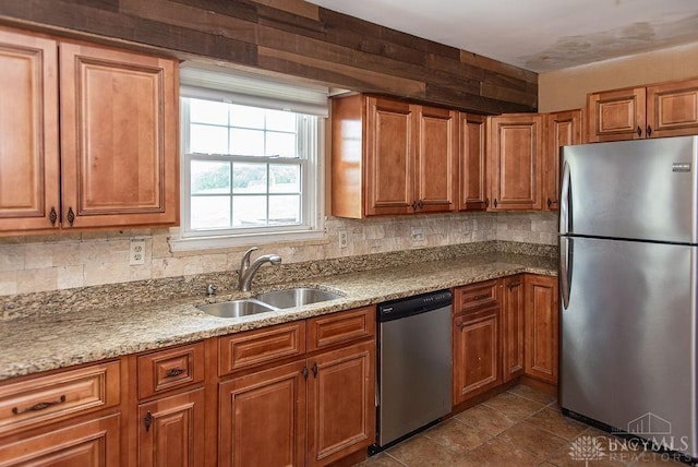 557 W N Bend Rd, Springfield Twp, OH 45224 - kitchen featuring appliances with stainless steel finishes, brown cabinetry, tasteful backsplash, and light stone countertops