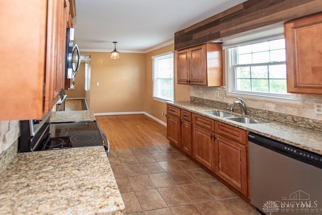 557 W N Bend Rd, Springfield Twp, OH 45224 - kitchen with appliances with stainless steel finishes, ornamental molding, plenty of natural light, brown cabinets, and backsplash