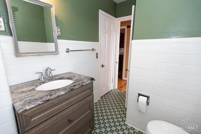 557 W N Bend Rd, Springfield Twp, OH 45224 - bathroom with tile walls, tile patterned floors, vanity, and a wainscoted wall
