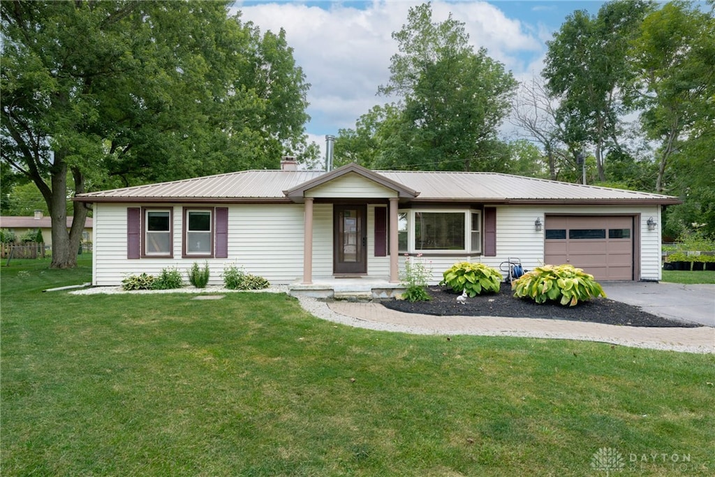 7430 Carroll Dr, West Milton, OH 45383 - ranch-style house with an attached garage, asphalt driveway, a metal roof, and a front lawn