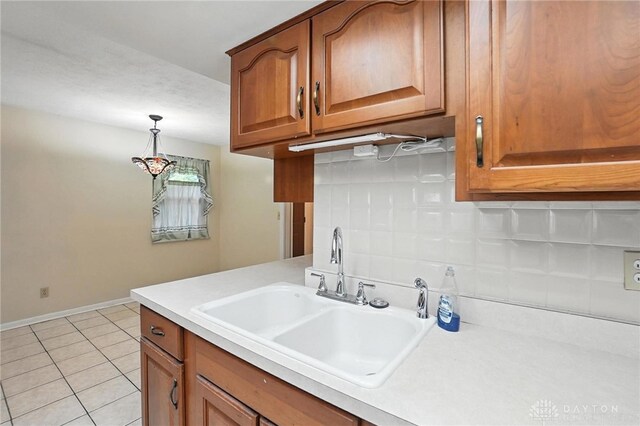 2184 Broadbent Way, Dayton, OH 45440 - kitchen with light countertops, brown cabinets, pendant lighting, and light tile patterned floors